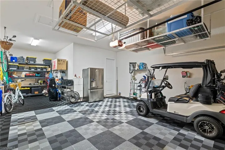Garage with high end refrigerator and a garage door opener