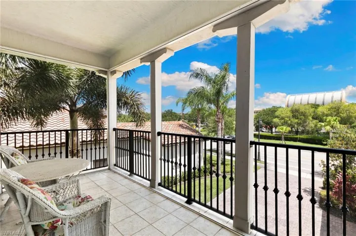 2nd floor Covered balcony featuring square tile flooring, white support columns, and black wrought iron railings