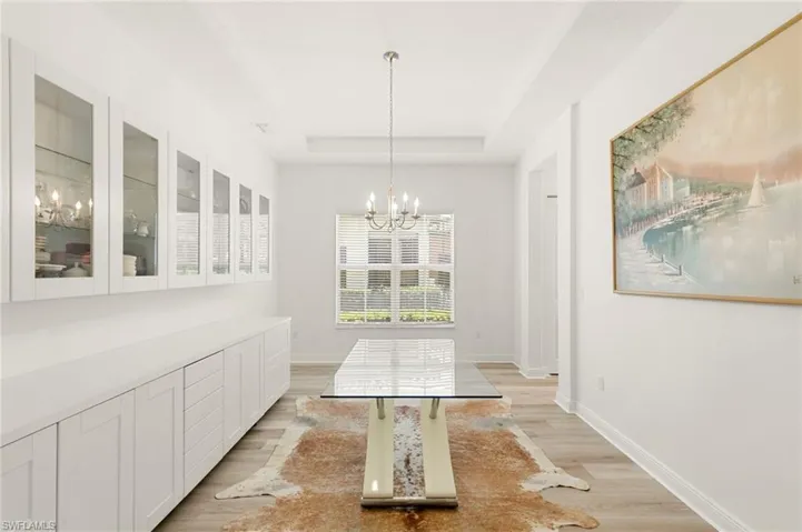 Dining area featuring custom built-ins, a contemporary chandelier and tray ceiling