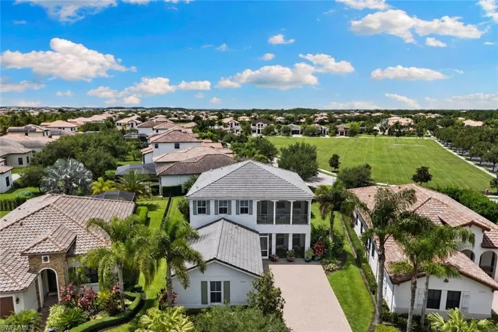 Aerial perspective showcasing a residential community with a large, manicured green space