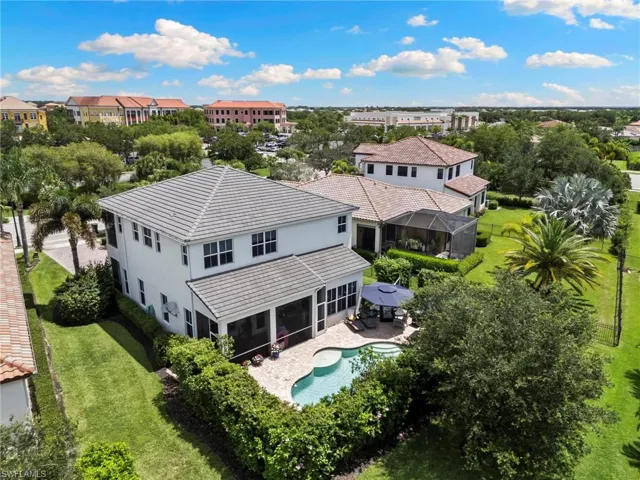Two-story residence featuring a tile roof, screened lanai, freeform swimming pool, and paver patio