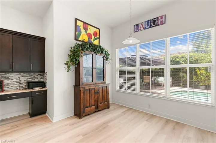 Light wood-finish flooring complements the modern built-in desk area
