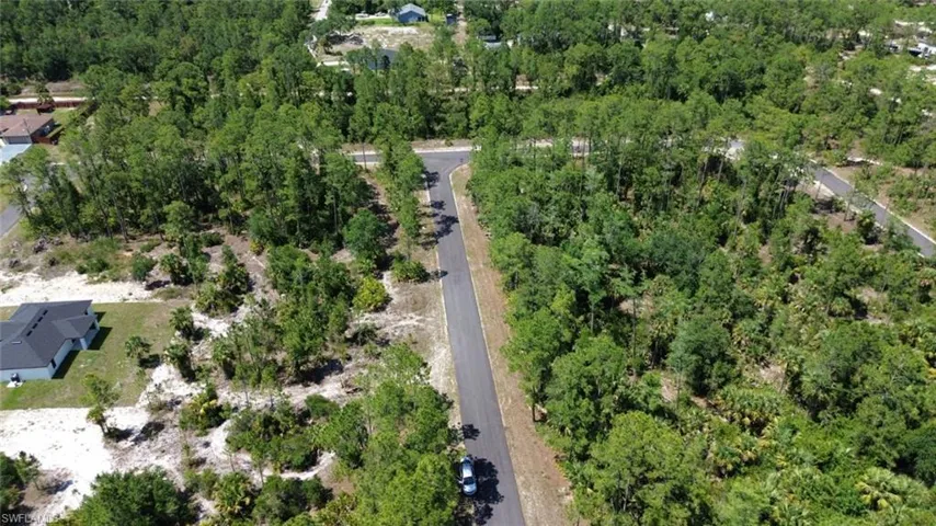 Aerial view of property's location featuring a forest