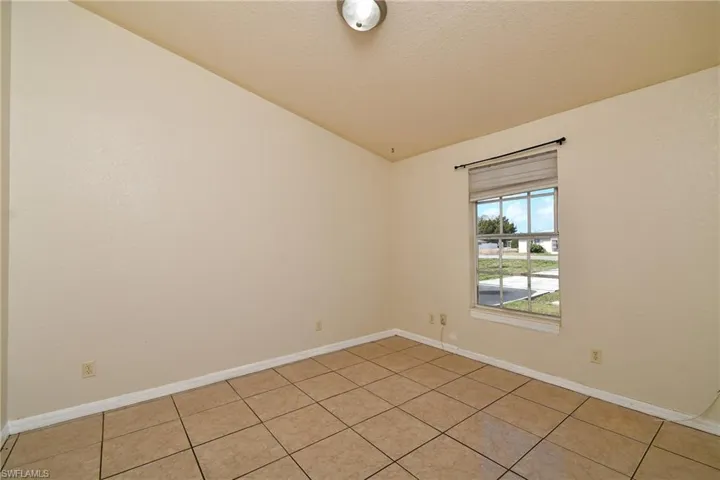 Empty room featuring light tile patterned floors and a textured ceiling