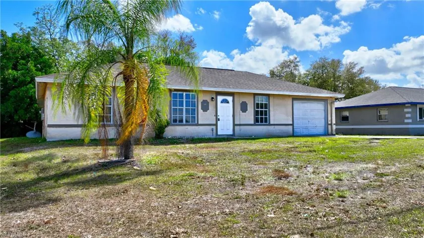 Single story home with stucco siding, an attached garage, a front lawn, and a shingled roof