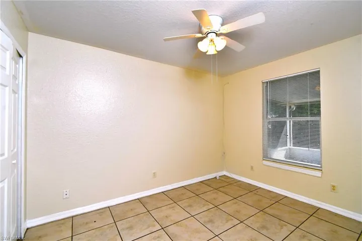 Unfurnished room with a ceiling fan, a textured ceiling, and light tile patterned flooring