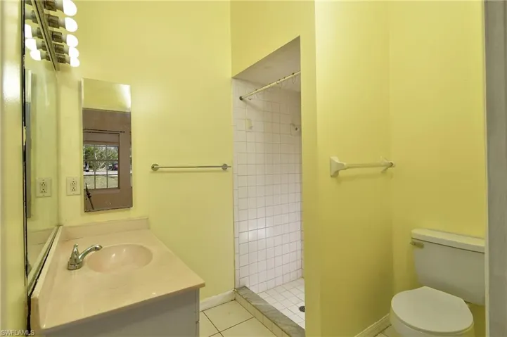 Full bathroom with vanity, a shower stall, and light tile patterned flooring