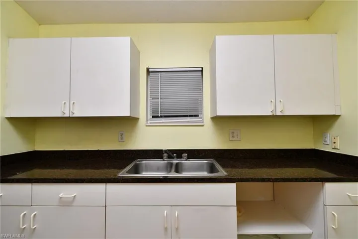 Kitchen with white cabinets and dark countertops
