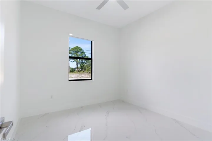 Unfurnished room featuring baseboards and light marble finish flooring