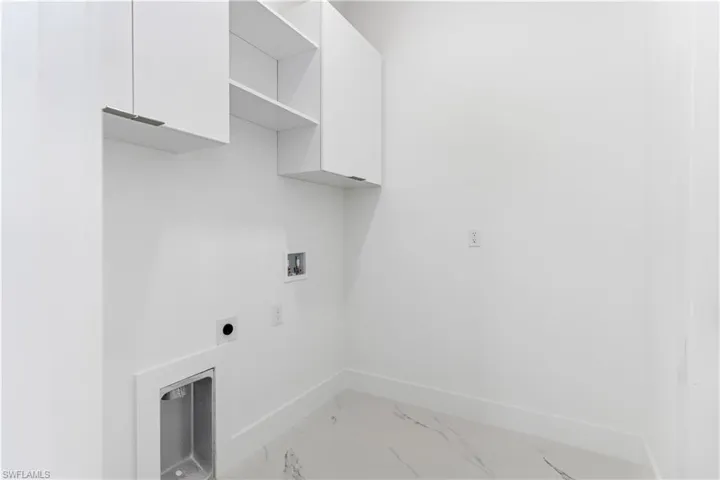 Laundry area featuring cabinet space, washer hookup, light marble finish floors, and hookup for an electric dryer