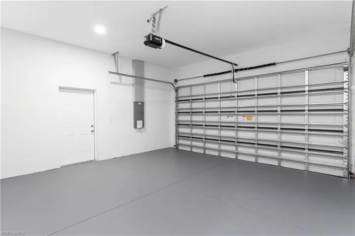 Garage featuring electric panel and a garage door opener