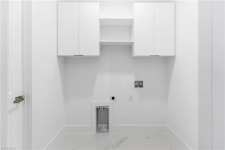 Laundry area with cabinet space, washer hookup, electric dryer hookup, and light marble finish floors