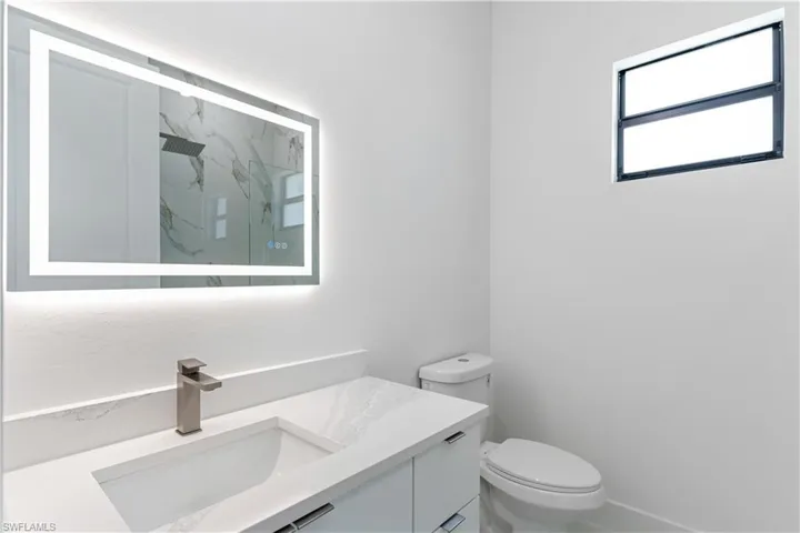 Bathroom with vanity and a marble finish shower
