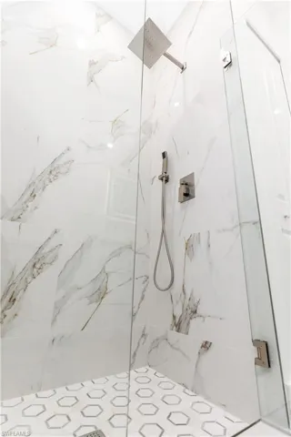 Full bathroom with a marble finish shower