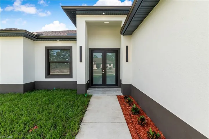 View of exterior entry with french doors and stucco siding