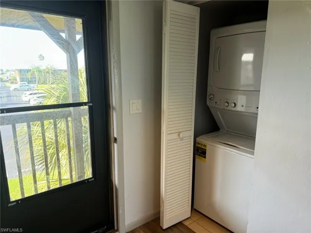 Washroom featuring stacked washer / drying machine