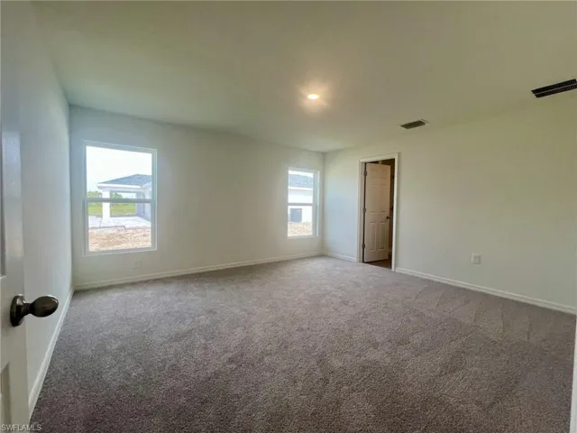 Carpeted empty room with baseboards