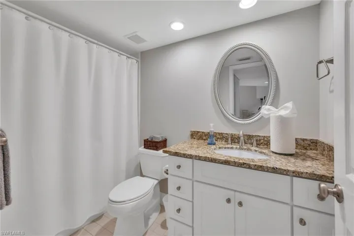 Bathroom featuring updated vanity & counters, a shower with curtain, recessed lighting, and light tile patterned flooring