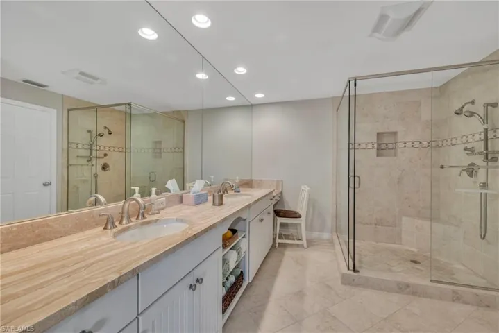 Bathroom with double vanity, a walk-in showerl, and recessed lighting