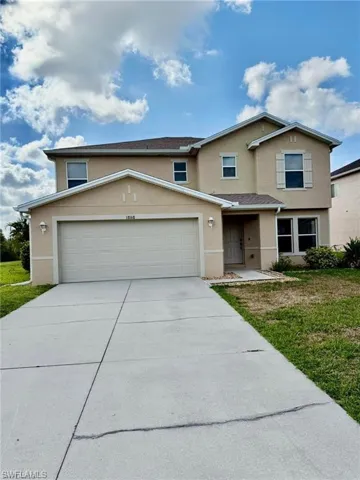 Traditional-style house featuring stucco siding, concrete driveway, a garage, and a front yard