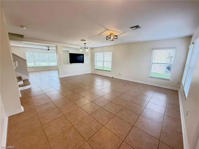 Spare room with light tile patterned flooring and baseboards