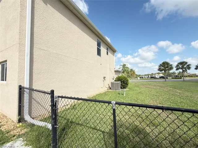 View of side of home with stucco siding and central AC