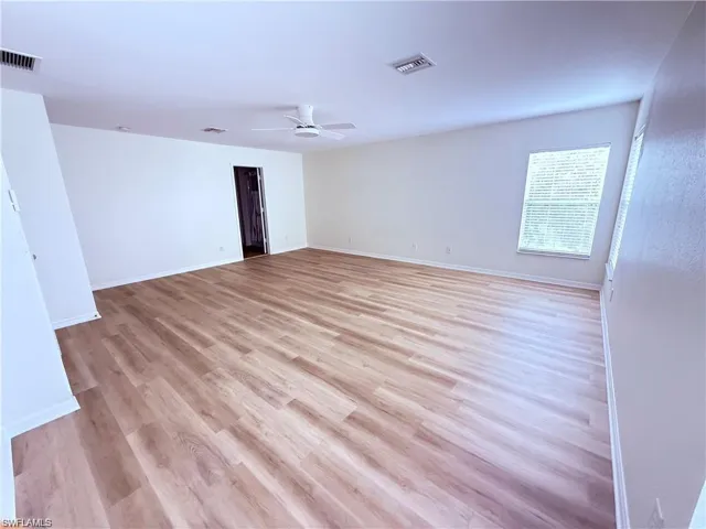 Spare room with ceiling fan, light wood finished floors, and baseboards