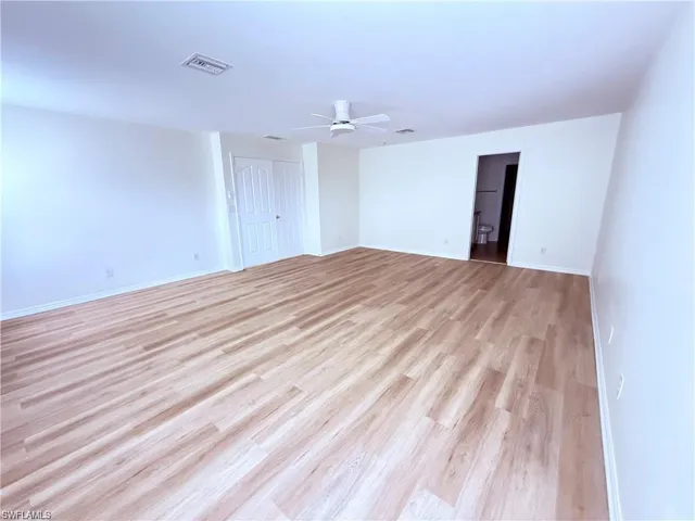 Unfurnished room with light wood finished floors, ceiling fan, and baseboards