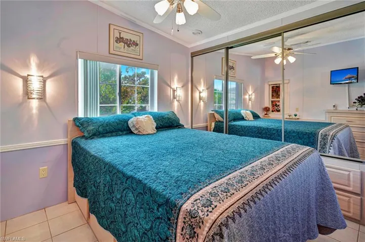 Tiled bedroom featuring a closet, ceiling fan, a textured ceiling, and crown molding