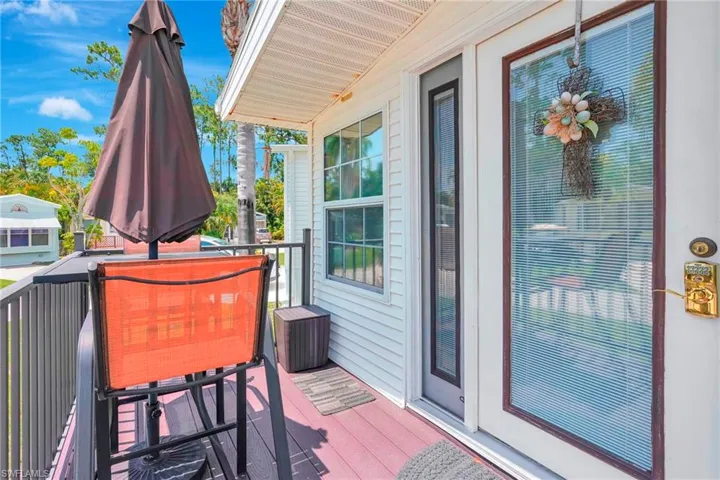 View of composite deck and front entry door with side lights