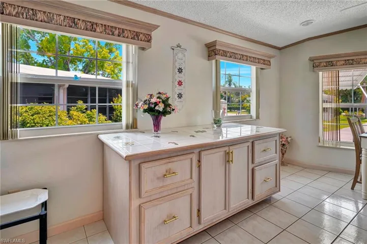 Kitchen featuring tile floors, ornamental buffet, and a textured ceiling
