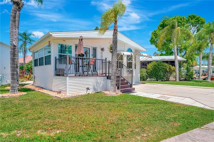 View of front of home featuring a front yard with deck and a patio on side of home
