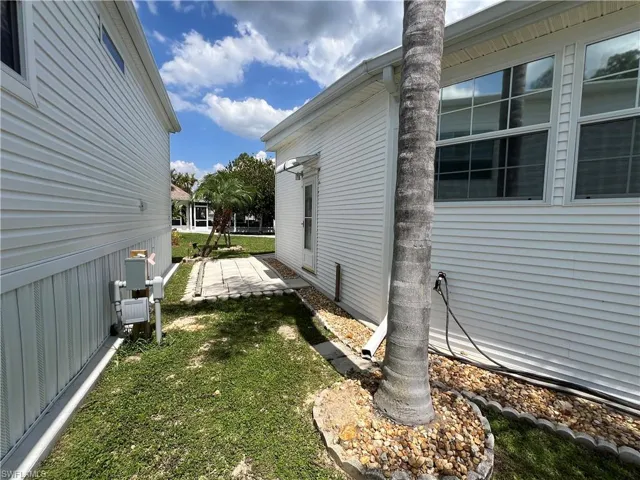 View of side of home with a yard and paver patio
