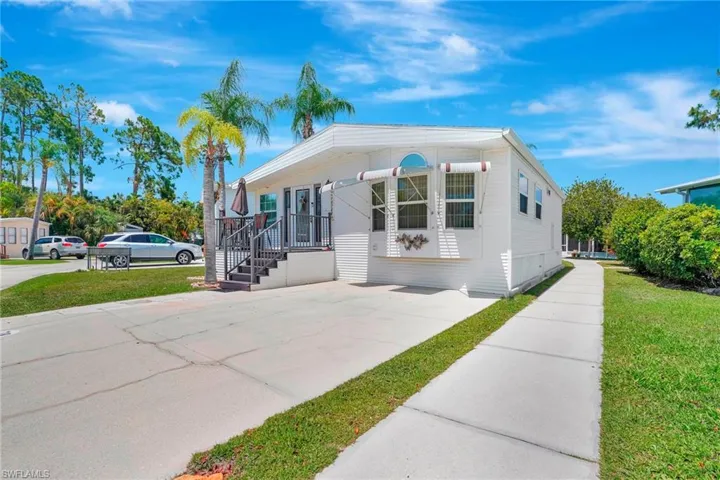 View of front of home with a front yard and deck 10702 Everglades Kite Cir
