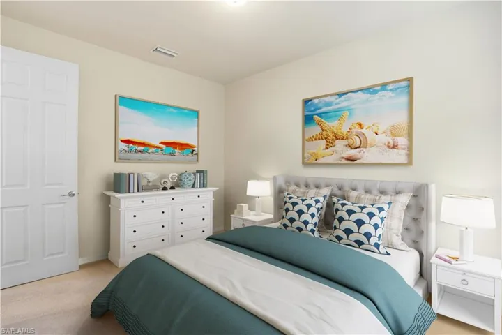 Bedroom featuring light carpet and baseboards