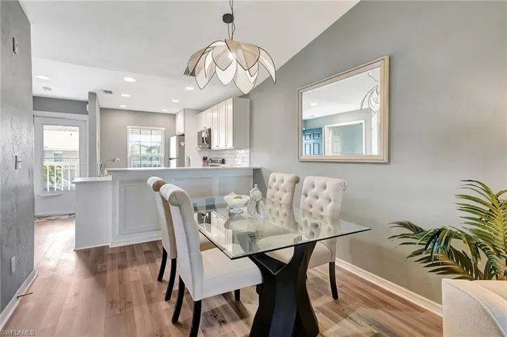 Dining room with light hardwood / wood-style floors and lofted ceiling
