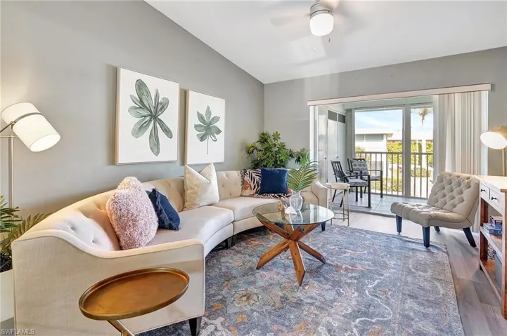 Living room with ceiling fan, lofted ceiling, and hardwood / wood-style flooring