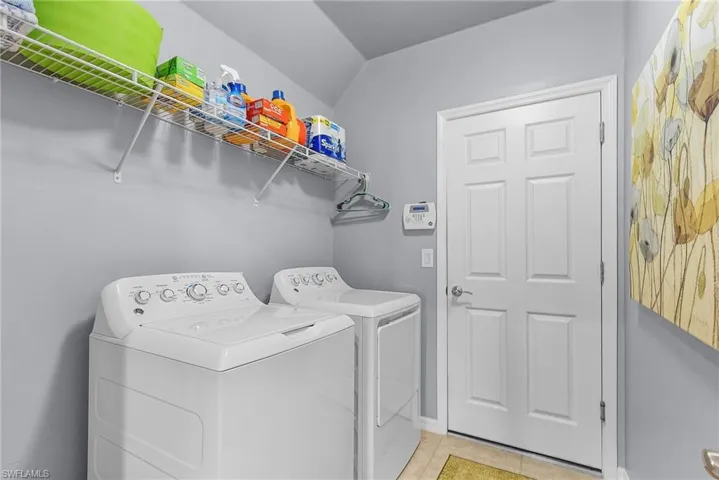 Washroom featuring light tile patterned floors and washer and dryer