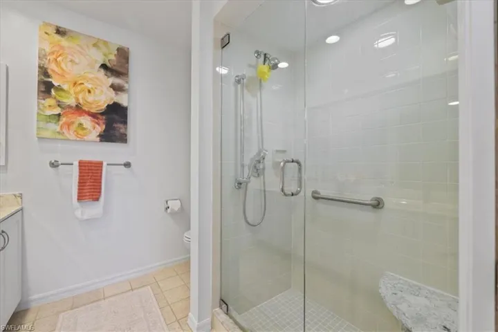 Full bathroom featuring vanity, a stall shower, and light tile patterned floors