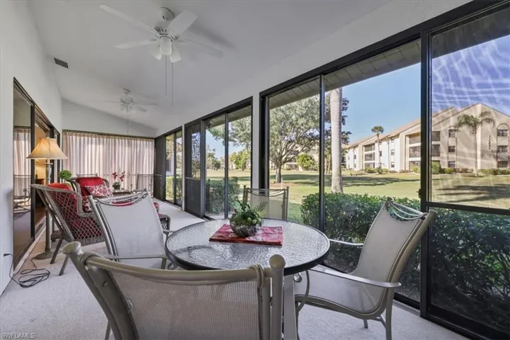 Sunroom featuring carpet flooring and vaulted ceiling