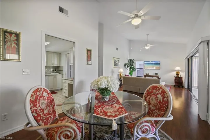 Dining area with light wood-type flooring, vaulted ceiling, and a ceiling fan