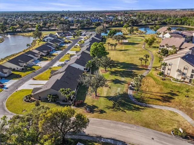 Aerial view of property and surrounding area featuring a large body of water and nearby suburban area