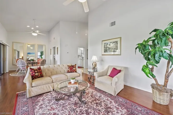 Living area featuring a ceiling fan, wood finished floors, vaulted ceiling, and recessed lighting