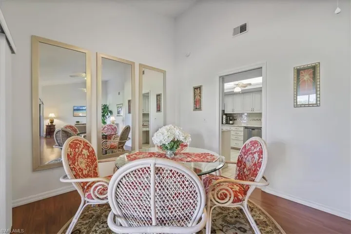 Dining room with dark wood-type flooring and a high ceiling