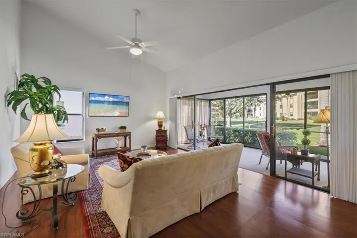 Living area featuring wood finished floors, lofted ceiling, and ceiling fan