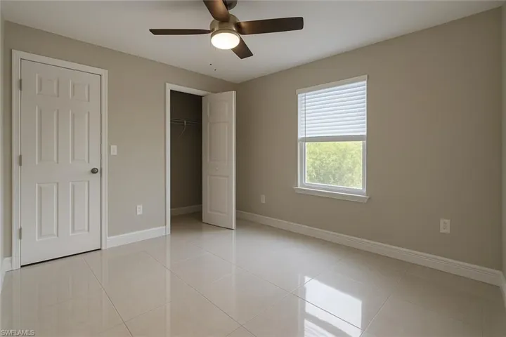 Unfurnished bedroom featuring ceiling fan and light tile patterned floors