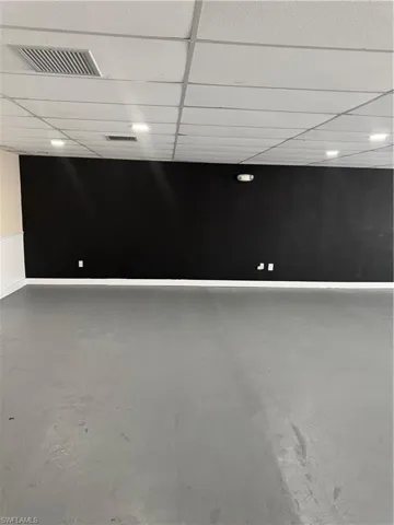 Spare room featuring a paneled ceiling, concrete flooring, and visible vents