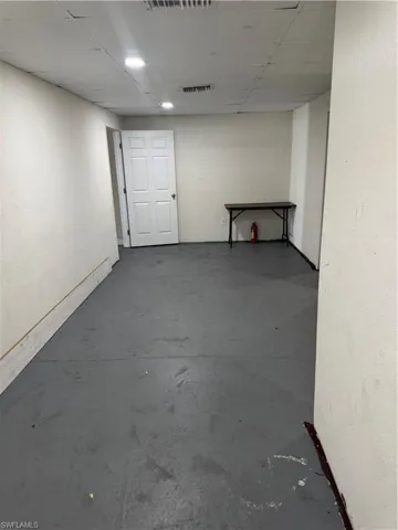 Basement featuring a drop ceiling, visible vents, and baseboards