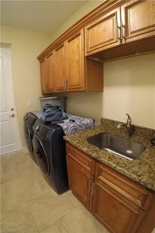 Laundry room with cabinets, sink, and washing machine and dryer
