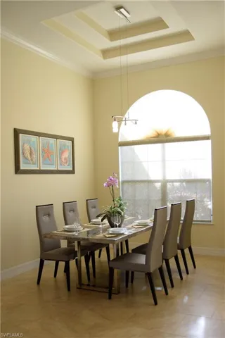 Dining area featuring a raised ceiling and crown molding